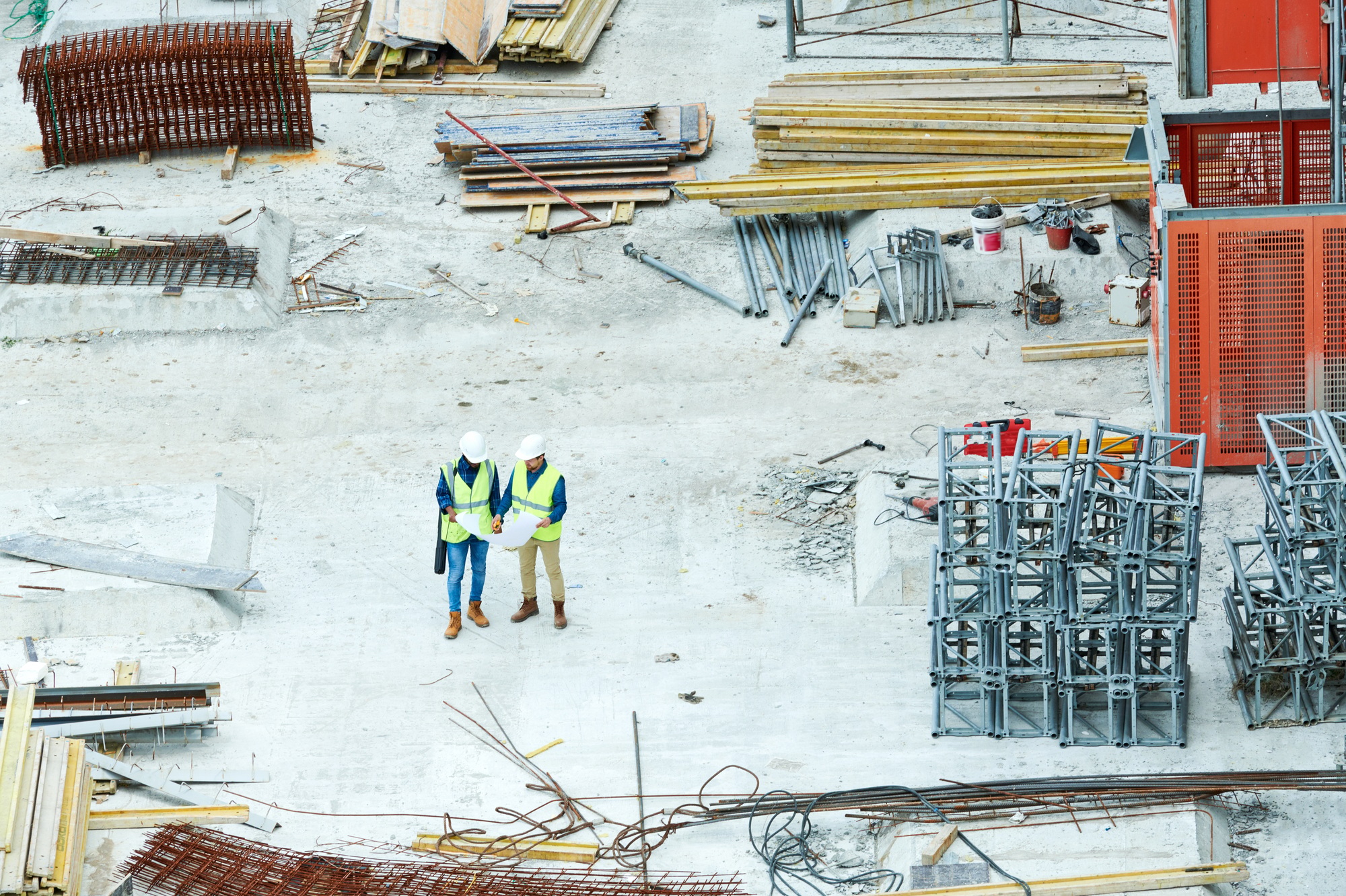 Building inspectors reading blueprint on construction site